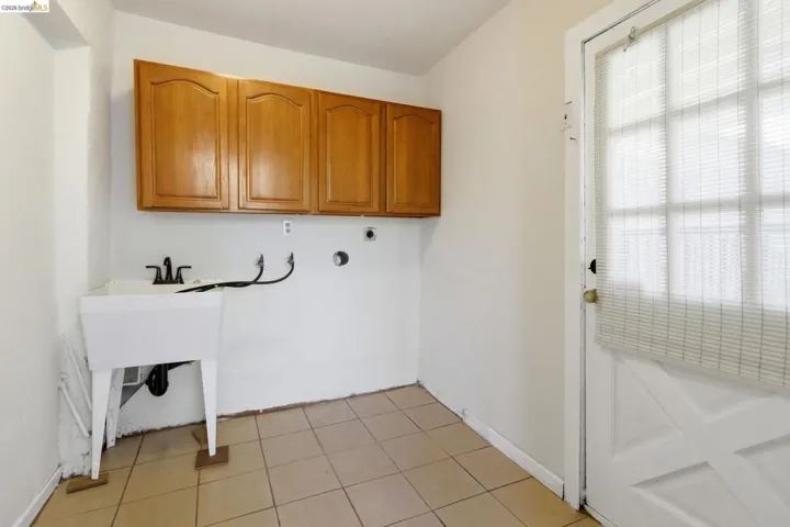 Laundry area featuring cabinet space, hookup for a washing machine, light tile patterned floors, and hookup for an electric dryer