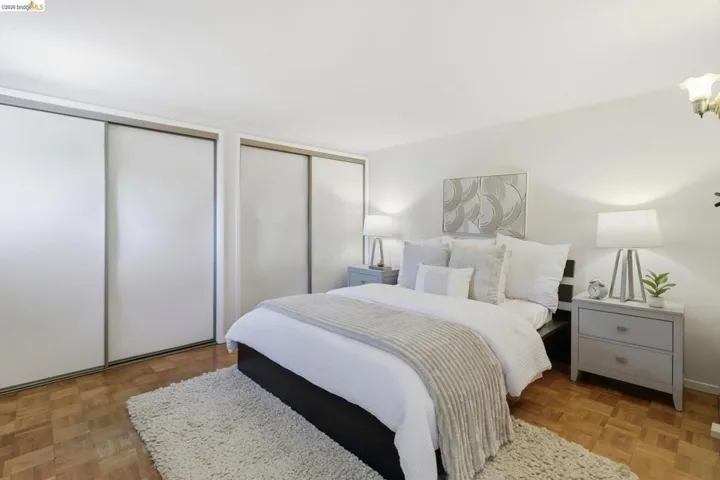 Bedroom featuring two closets and parquet flooring
