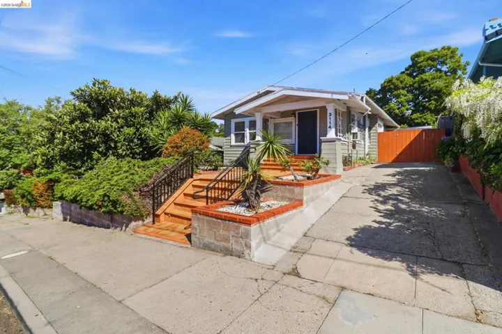 Bungalow-style house with a gate, driveway, and covered porch