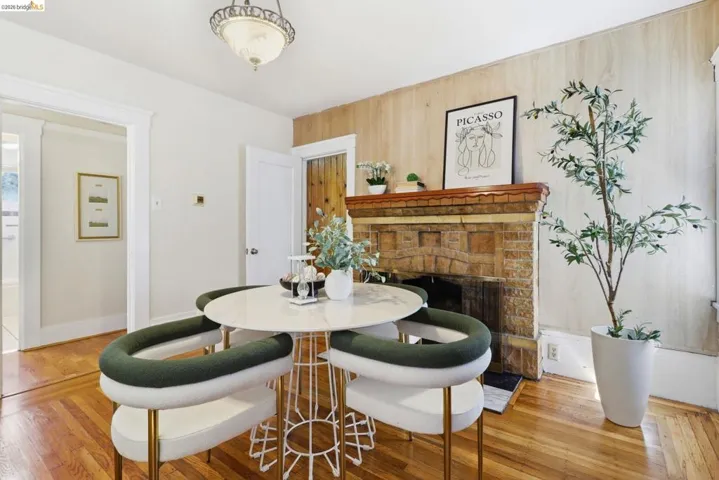 Dining area featuring light wood finished floors, a brick fireplace, and wooden walls