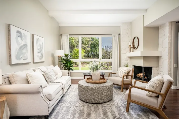 Light-filled living room w/beamed ceilings & romantic fireplace!