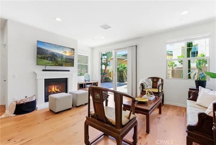 Bright and inviting living room featuring a cozy fireplace and seamless indoor-outdoor flow with direct access to the private backyard patio.