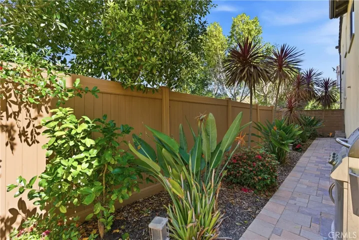 Thoughtfully landscaped side yard featuring lush greenery and a private walkway, creating a peaceful outdoor retreat.