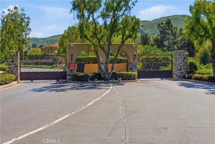 Secure gated community entrance providing peace of mind, exclusivity, and a welcoming first impression surrounded by lush, mature landscaping.