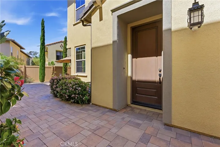 Welcoming entry with private courtyard and paver hardscape, offering both charm and added privacy.