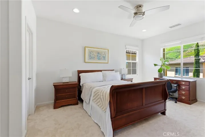 Generously sized primary suite featuring abundant natural light, a functional layout, and space for a dedicated seating or workspace area.