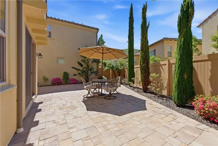 Private backyard patio with paver hardscape and outdoor seating area, ideal for dining, entertaining, or relaxing under the sun.