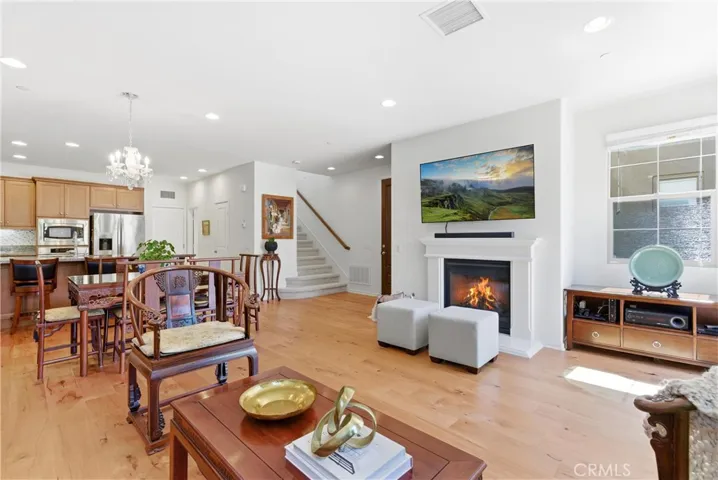 Light-filled living space featuring a cozy fireplace, expansive layout, and seamless connection to the kitchen and dining areas.