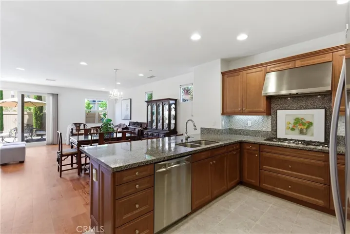 Open-concept kitchen and living space featuring granite countertops, stainless steel appliances, and seamless flow into the dining and family areas—ideal for everyday living and entertaining.