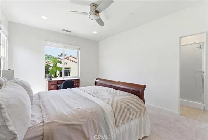Light-filled primary bedroom offering a spacious layout, soft natural tones, and peaceful views of the surrounding hills.