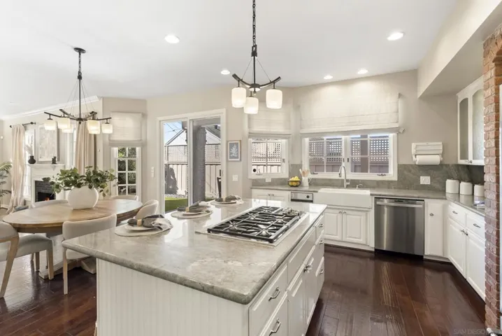 A light-filled culinary space where an expansive island anchors the room, flowing effortlessly into dining and outdoor access, creating a natural setting for gathering and everyday living.