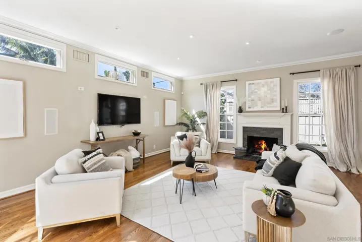 A relaxed yet refined family room, where soft light, warm wood floors, and a glowing fireplace create an inviting setting for everyday comfort and effortless gathering.