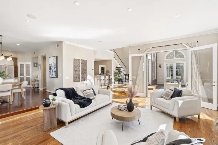 An effortless flow of light and space defines this open living area, where warm wood floors, soft neutral tones, and seamless transitions create an inviting setting for both relaxed living and refined entertaining.