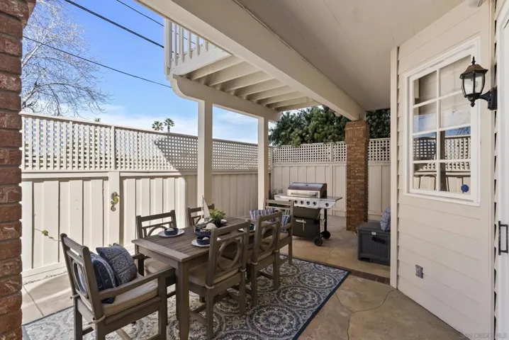 A sheltered outdoor setting designed for casual dining and weekend grilling, where privacy fencing and covered space create a comfortable extension of everyday living.