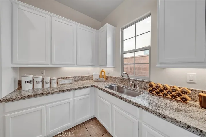 The main kitchen features a second sink and abundant cabinetry for added convenience and storage