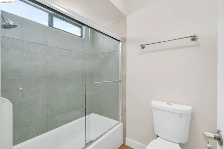 Full bath with toilet and enclosed tub / shower combo