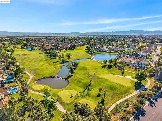 Aerial perspective of suburban area featuring a water and mountain view and a golf club