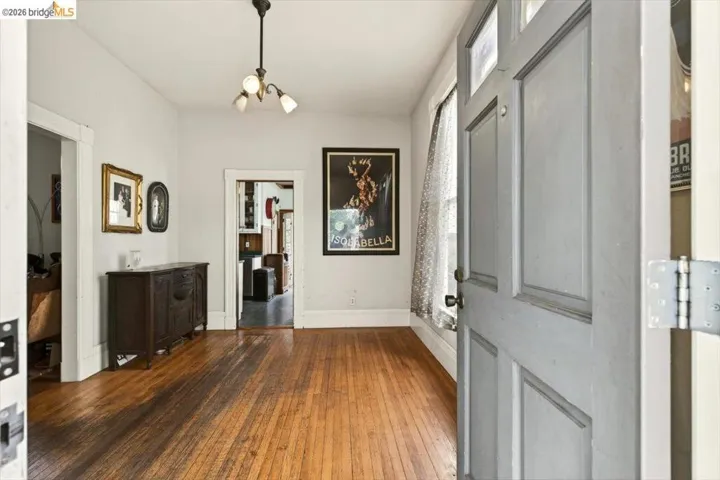 Entrance foyer with dark wood finished floors and a chandelier