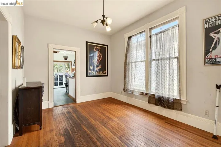 Unfurnished dining area with wood-type flooring and hanging lights