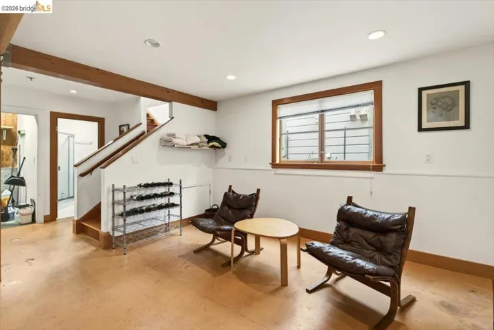Sitting room with recessed lighting, beam ceiling, and concrete flooring
