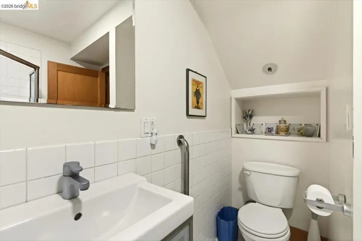 Bathroom with toilet and tile walls