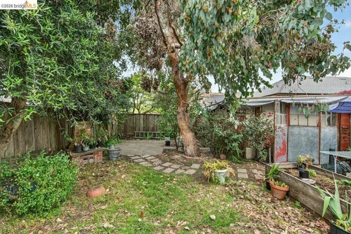 Fenced backyard featuring a patio and a vegetable garden