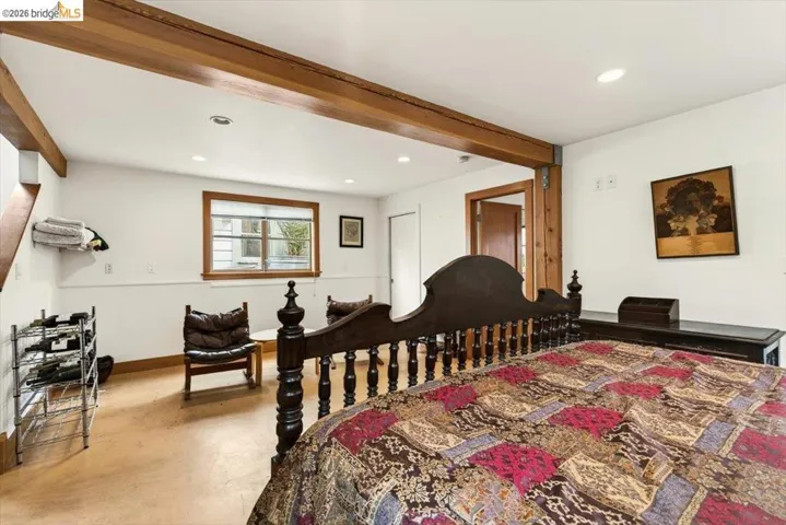 Bedroom featuring beamed ceiling, finished concrete floors, and recessed lighting