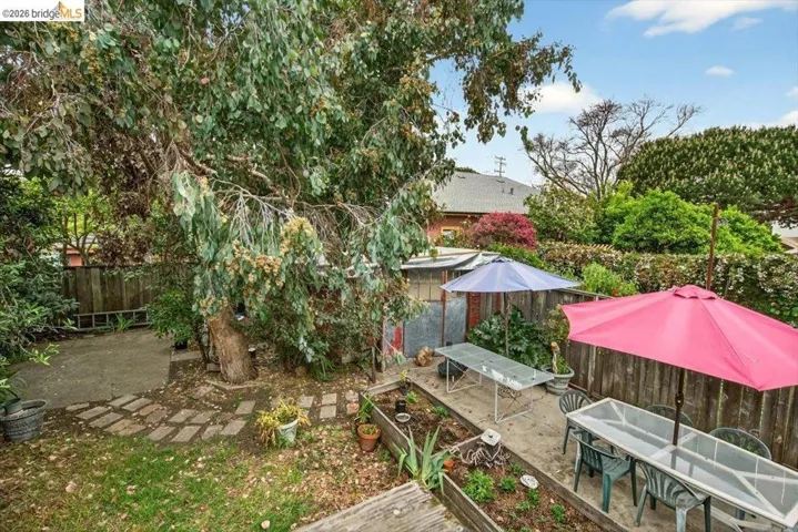 Fenced backyard featuring a patio, outdoor dining space, and a vegetable garden
