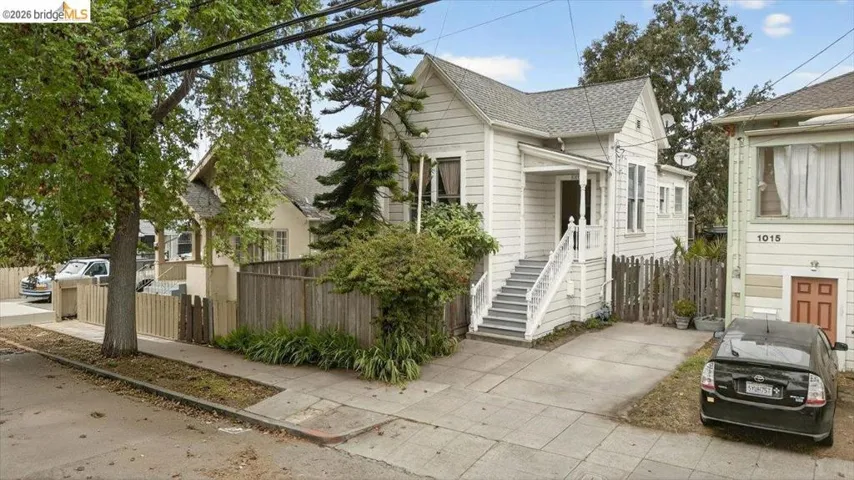 View of home's exterior with roof with shingles and stairway