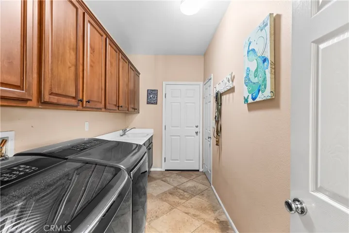 Downstairs laundry room with sink and large storage closet.