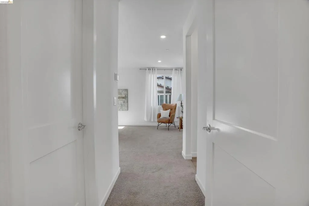 Hall with recessed lighting and light carpet