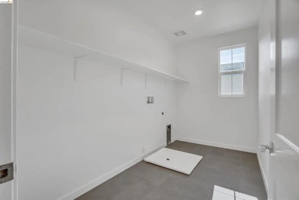 Laundry area featuring dark tile patterned flooring, washer hookup, hookup for a gas dryer, and recessed lighting