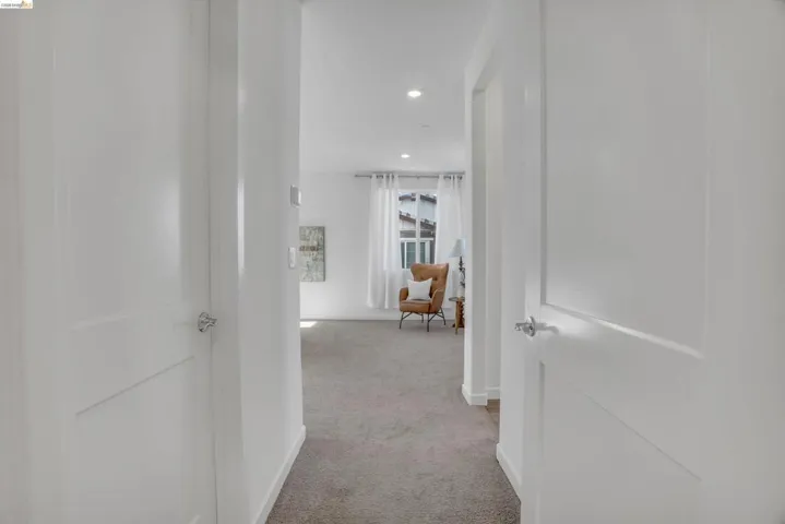 Hall with recessed lighting and light carpet