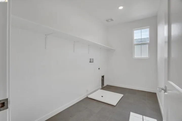 Laundry area featuring dark tile patterned flooring, washer hookup, hookup for a gas dryer, and recessed lighting