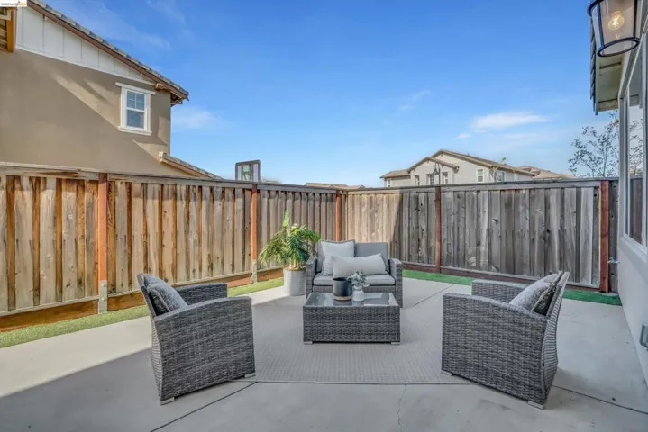 Fenced backyard with an outdoor hangout area and a patio area