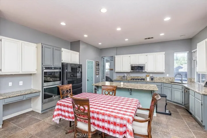 Looking from family room into breakfast area and kitchen.  Granite Countertops, double ovens & microwave. Island/breakfast bar. Pantry.