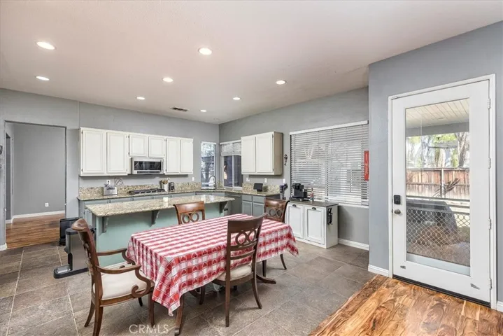 Portion of the kitchen.  Door going out to covered patio. Lots of recessed lighting.