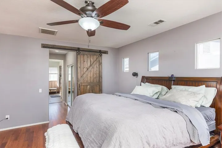 Primary suite with sliding barn door into adjoining bath.