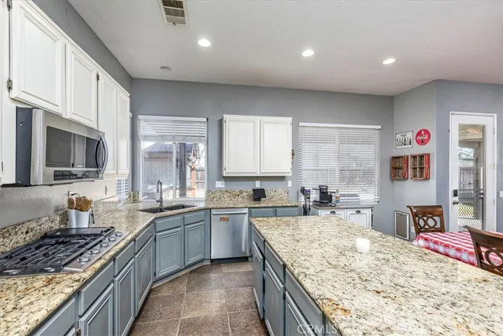 Slab granite counters.  Stainless steel appliances. Windows looking out to back yard.