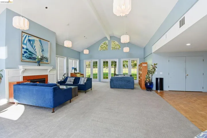 Living room featuring a warm lit fireplace, french doors, and parquet floors