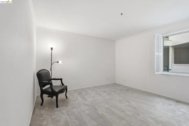 Unfurnished room featuring light colored carpet and crown molding