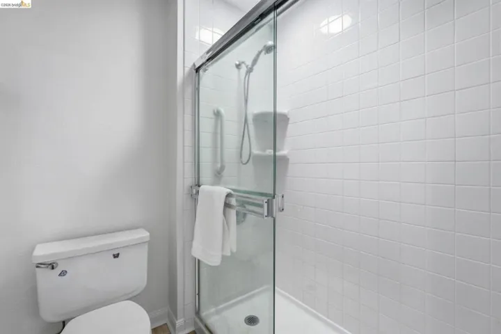 Full bathroom featuring toilet and a shower stall