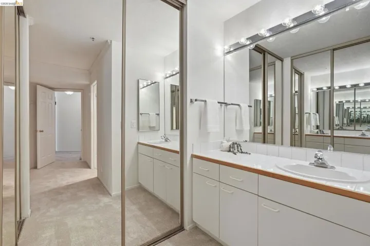 Bathroom with two vanities and light colored carpet