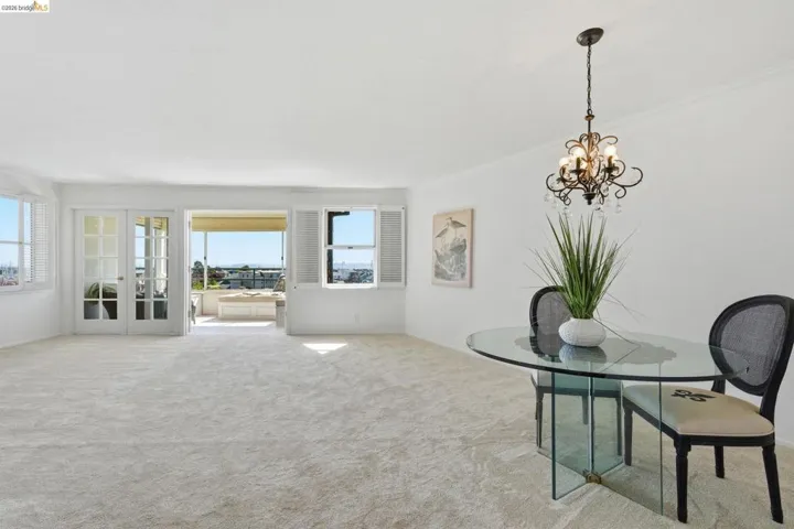 Dining space featuring light colored carpet, hanging lights, french doors, and ornamental molding