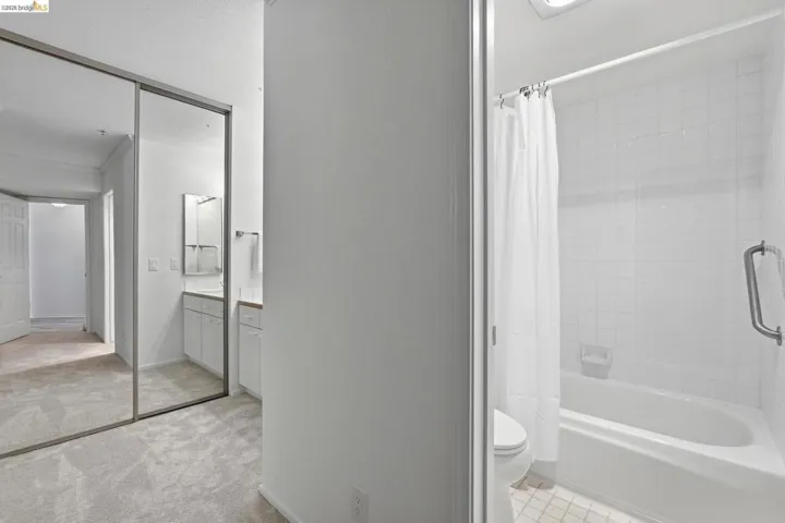 Full bathroom with shower / bath combination with curtain, vanity, and light carpet