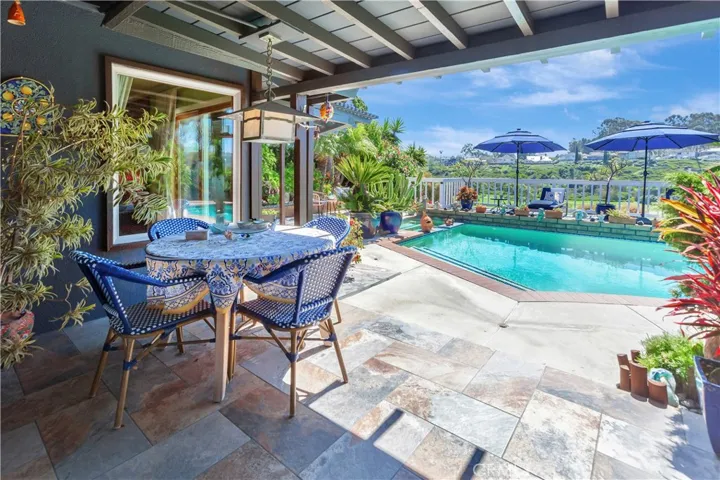 Step outside of living/dining area to enjoy covered patio space and serene views of pool and golf course.