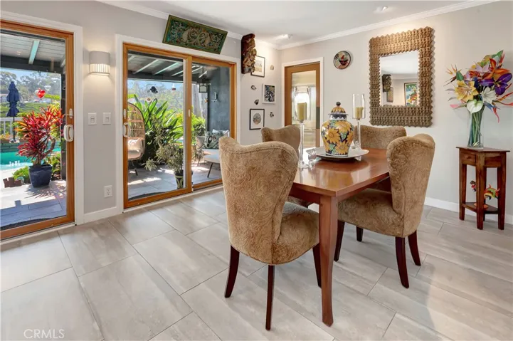 Formal dining room overlooking rear patio with views of golf course and pool.