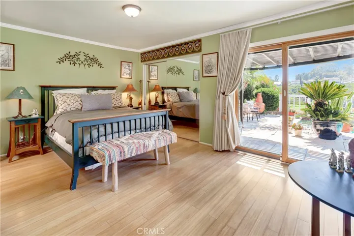 Spacious primary bedroom with lots of natural lighting, views, and direct access to pool/spa area.