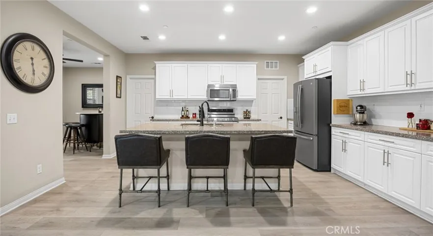 Kitchen area with white shaker style cabinets