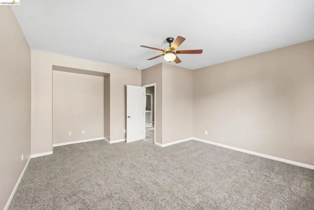 Unfurnished bedroom featuring carpet flooring and ceiling fan